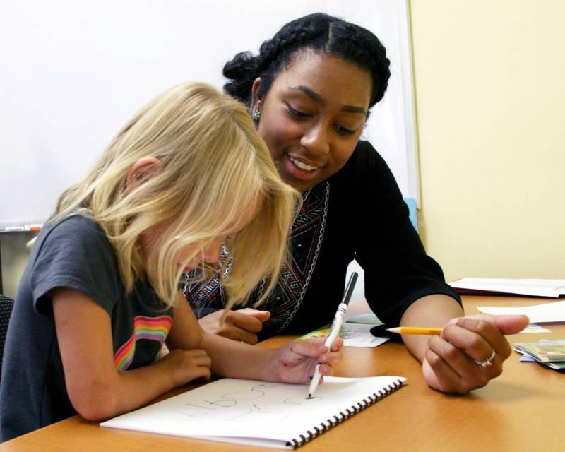 学生教师帮助幼儿学习.